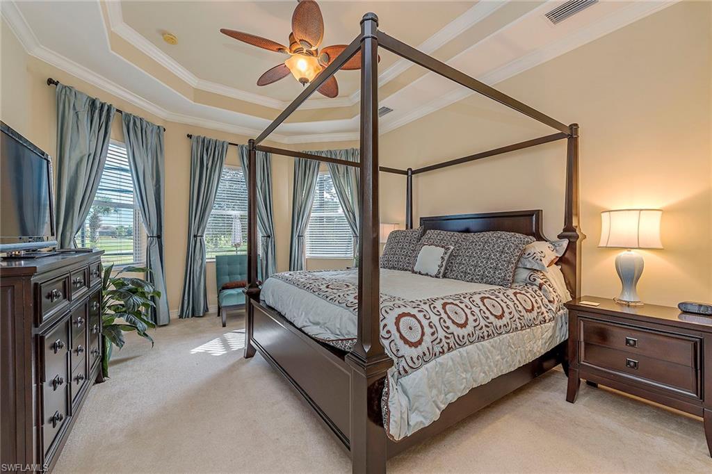 7812 Valencia Court Naples, FL 34113 - Photo 5 of 12 a bedroom with a bed flat screen tv and a large window