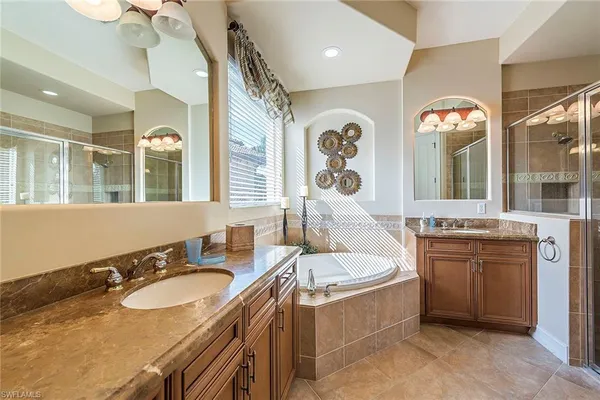 a spacious bathroom with a granite countertop tub a double vanity sink and a mirror
