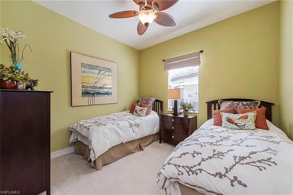a bedroom with two beds and a chandelier