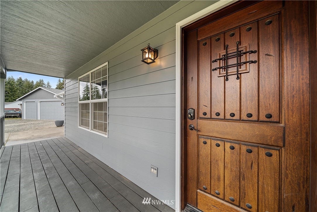 7810 196th Lane Southwest Rochester, WA 98579 - Photo 3 of 36 a view of a porch with wooden floor and front door