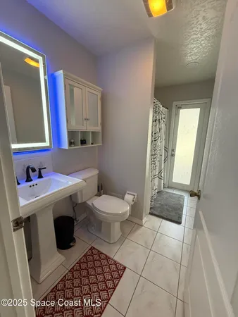 a bathroom with a toilet a sink and a mirror