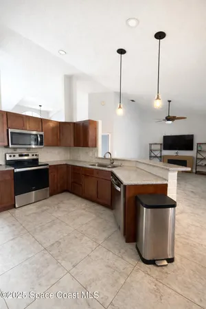 a kitchen with stainless steel appliances kitchen island granite countertop a sink and a stove