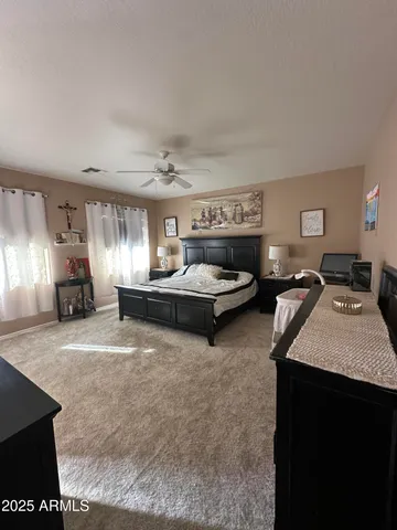 a bedroom with a bed and a ceiling fan