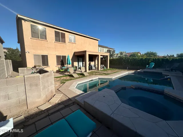a front view of a house with garden and sitting area