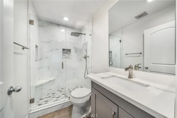 a bathroom with a sink a toilet and shower