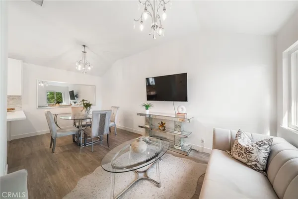 a living room with furniture a flat screen tv and kitchen view