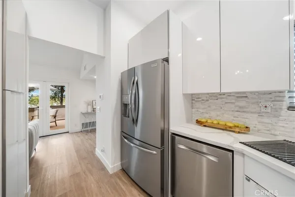 a kitchen with stainless steel appliances granite countertop a refrigerator and a stove