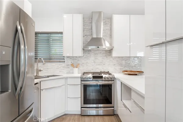 a kitchen with stainless steel appliances granite countertop a stove and a refrigerator