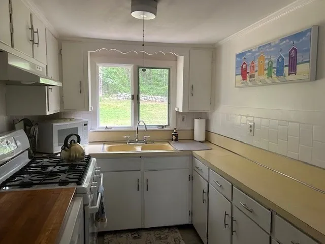 a kitchen with a sink stove and cabinets