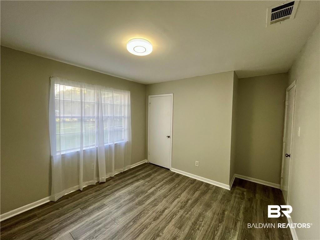 8636 Boe Road Irvington, AL 36544 - Photo 22 of 22 Spare room featuring baseboards and dark wood finished floors