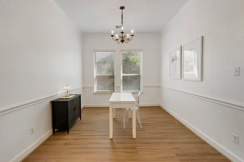 a view of a room with wooden floor windows and chandelier