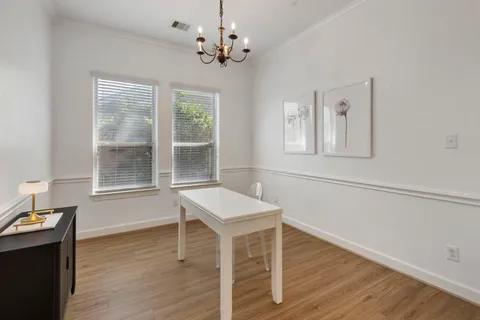 a kitchen with stainless steel appliances a refrigerator a stove a sink a dining table and chairs