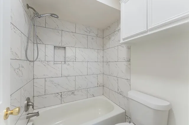 a spacious bedroom with a bed and a lamp