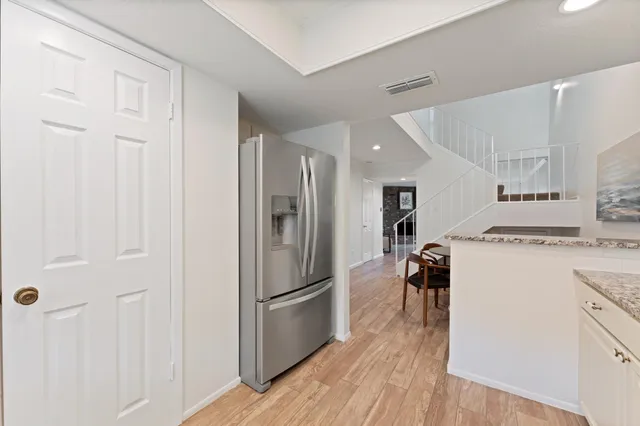 a kitchen with cabinets stainless steel appliances a sink and wooden floor