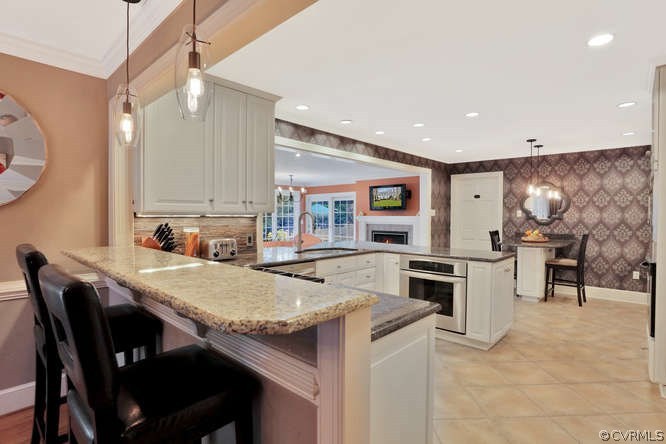 1821 Castlebridge Road Midlothian, VA 23113 - Photo 7 of 40 a kitchen with a dining table chairs and refrigerator