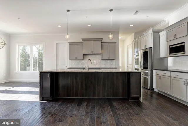 a kitchen with stainless steel appliances granite countertop a refrigerator a sink dishwasher a stove and white cabinets with wooden floor