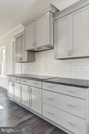a kitchen with granite countertop white cabinets and sink