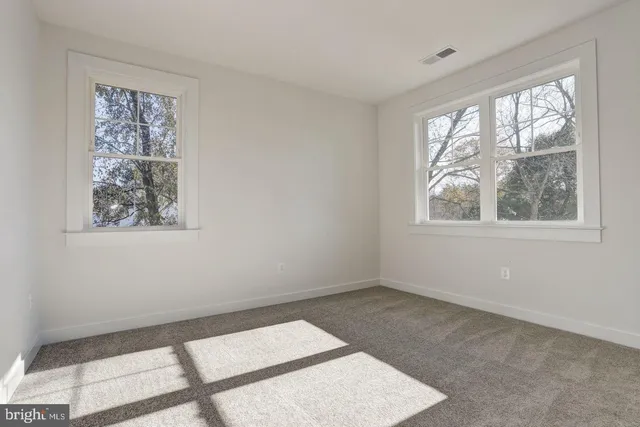 a view of a big room with windows and chandelier fan
