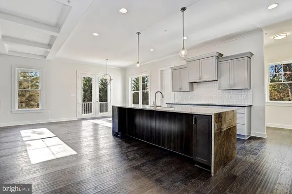a kitchen with kitchen island granite countertop wooden floors granite counter tops and a window