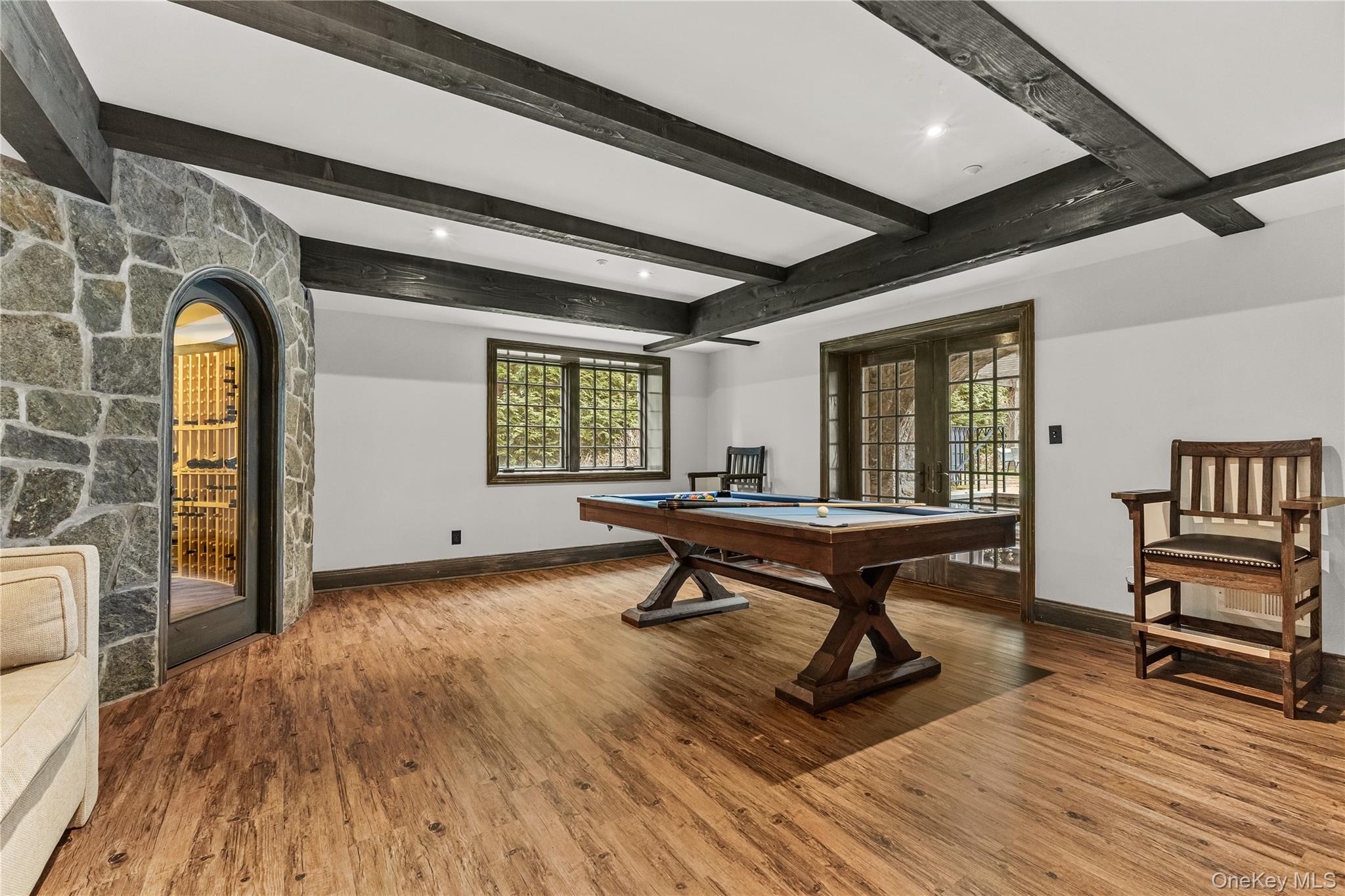 19 Park Drive South Rye, NY 10580 - Photo 35 of 42 Exposed timber beams and wide-plank floors anchor this sophisticated entertainment suite. French doors offer seamless outdoor access, flooding the billiards area with natural light.