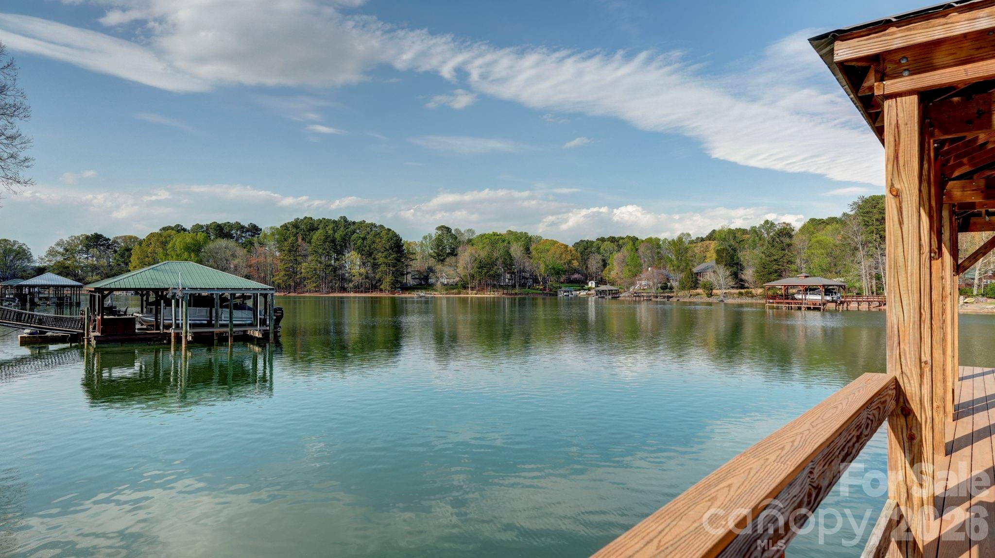 644 Normandy Road Mooresville, NC 28117 - Photo 31 of 32 a view of a lake with a table and chairs under an umbrella