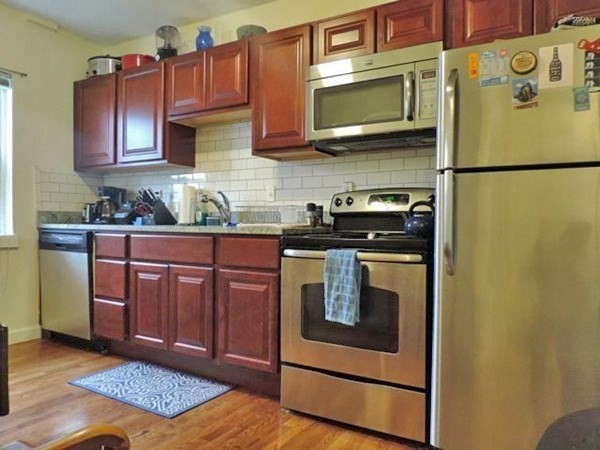 1-4 Schrepel Place Boston, MA 02127 - Photo 11 of 13 a kitchen with stainless steel appliances granite countertop a stove a microwave and cabinets