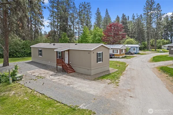 a view of a house with a yard and trees