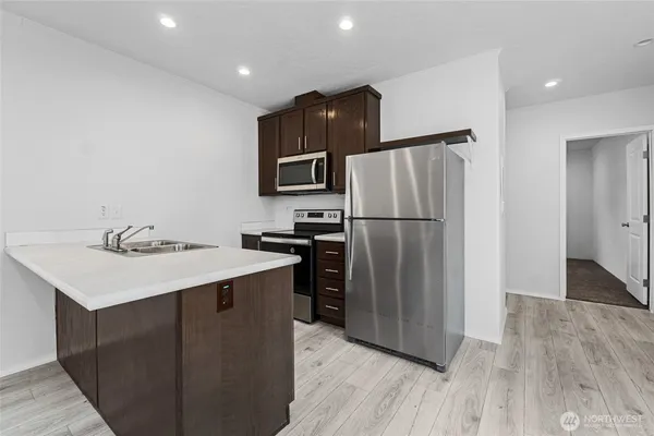 a kitchen with kitchen island a sink appliances and cabinets