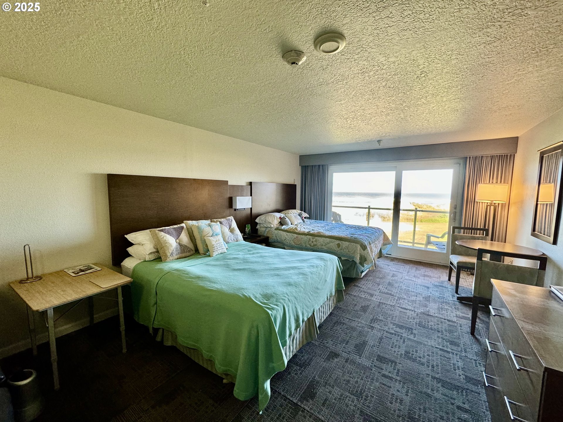 88416 1st Avenue, Unit 201 Florence, OR 97439 - Photo 3 of 29 a bedroom with a bed a table and chair