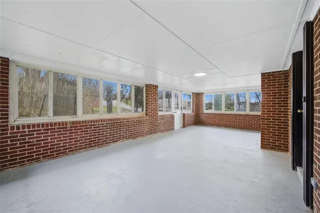 an empty room with large window and fireplace