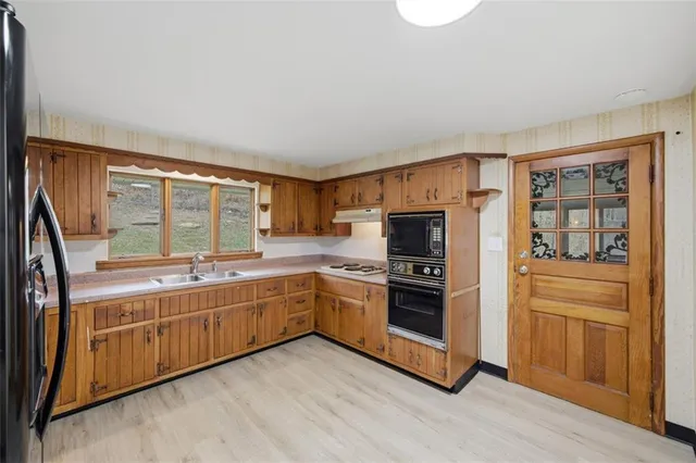 a large kitchen with stainless steel appliances granite countertop a stove and a sink