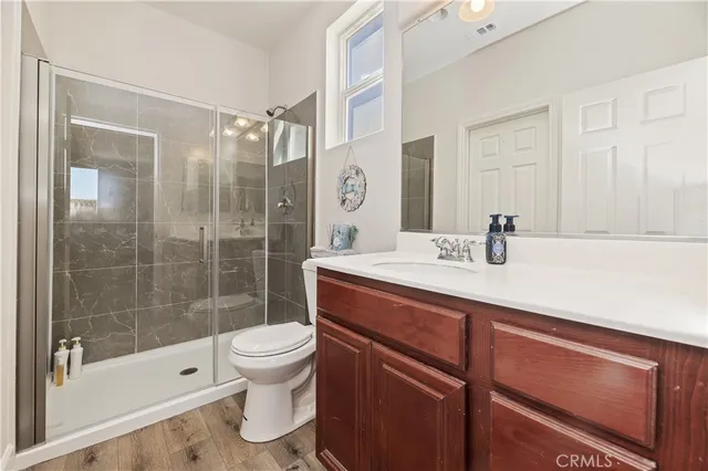 a bathroom with a sink a toilet and shower