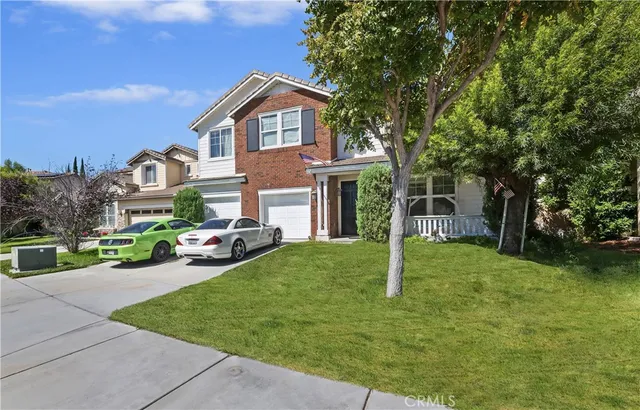 a front view of a house with a yard and trees