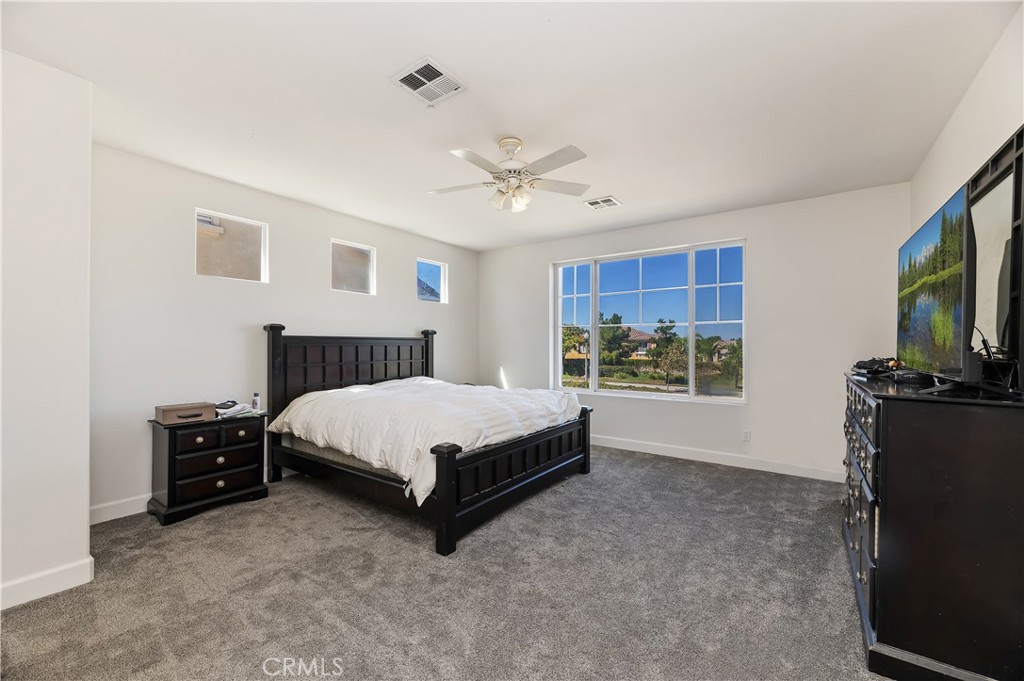 31244 Locust Court Temecula, CA 92592 - Photo 24 of 30 a spacious bedroom with a bed and a flat screen tv