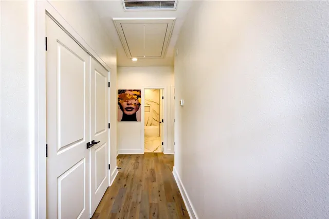 a view of a hallway with wooden floor and entryway