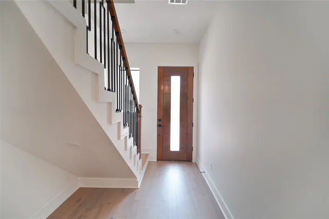a view of staircase with wooden floor and white walls