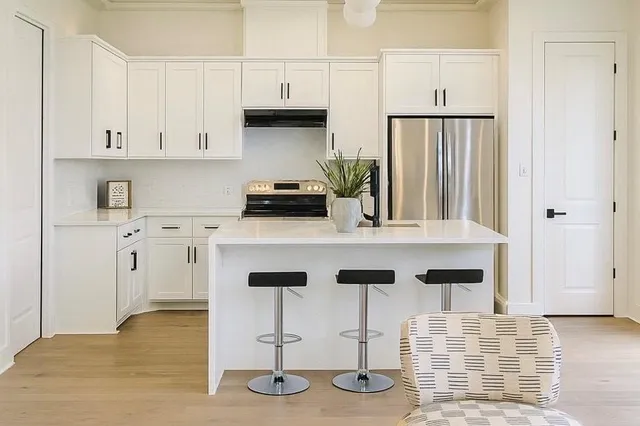 a kitchen with white cabinets and appliances