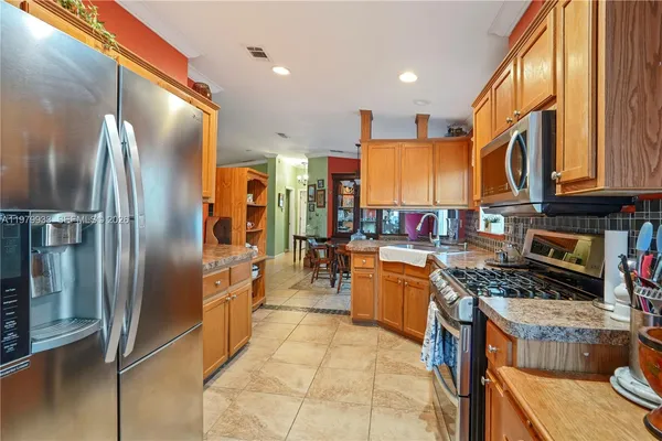 a kitchen with stainless steel appliances granite countertop a refrigerator a stove and a sink