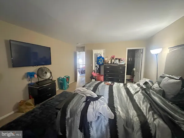 a bedroom with a bed and a flat tv screen on dresser