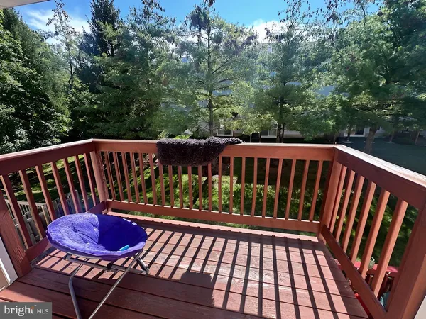 a view of a balcony with chairs and a potted plant