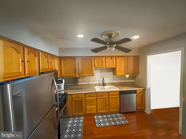 a kitchen with stainless steel appliances granite countertop a sink a stove and a refrigerator