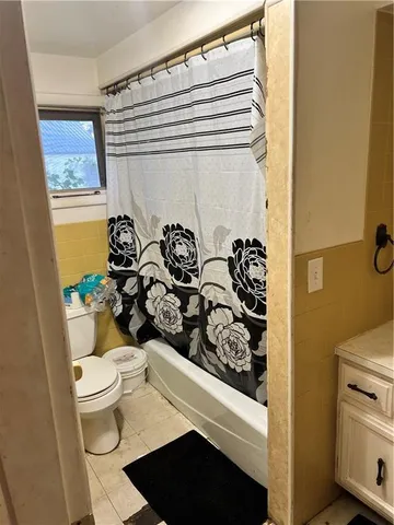 a bathroom with a toilet and a shower curtain