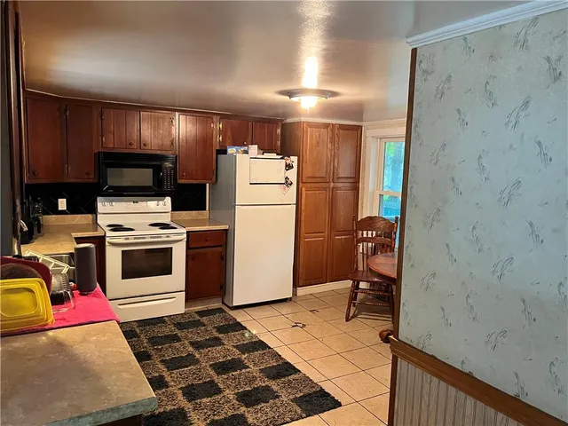 a storage room with stainless steel appliances wooden floor and view living room