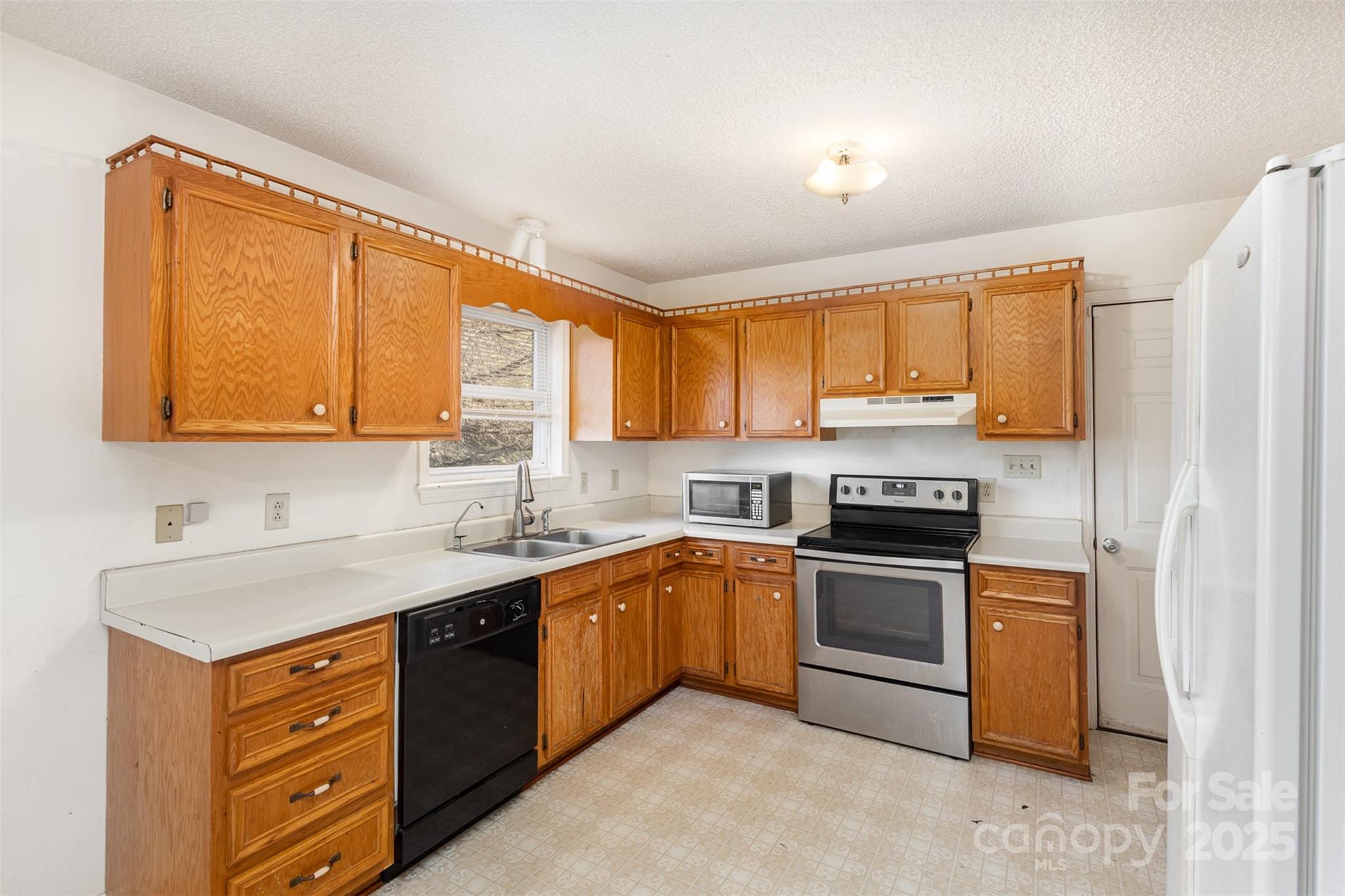 2888 Robinson Road Newton, NC 28658 - Photo 12 of 26 a kitchen with stainless steel appliances granite countertop a sink stove and refrigerator