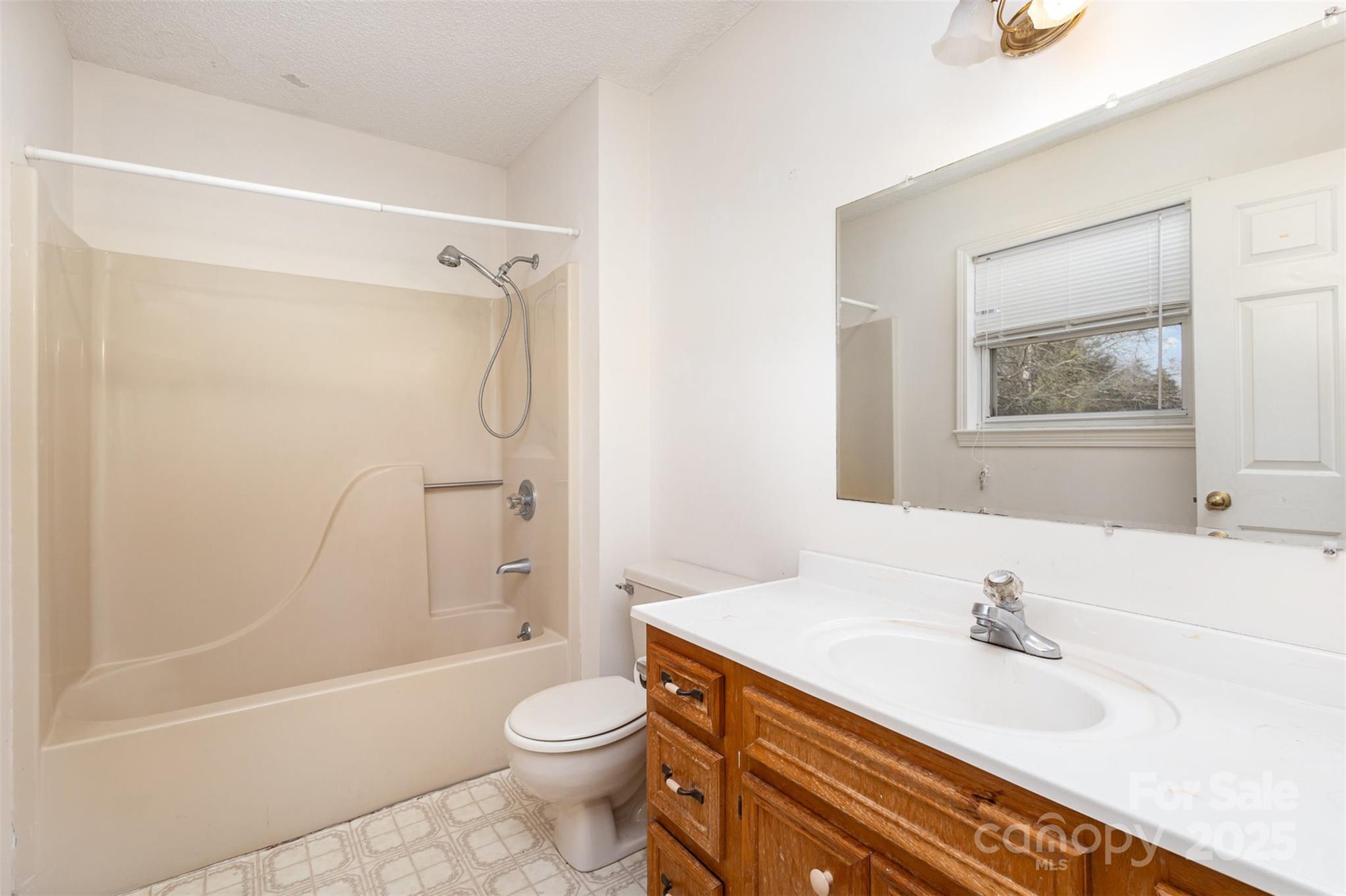 2888 Robinson Road Newton, NC 28658 - Photo 20 of 26 a bathroom with a granite countertop sink a toilet and shower