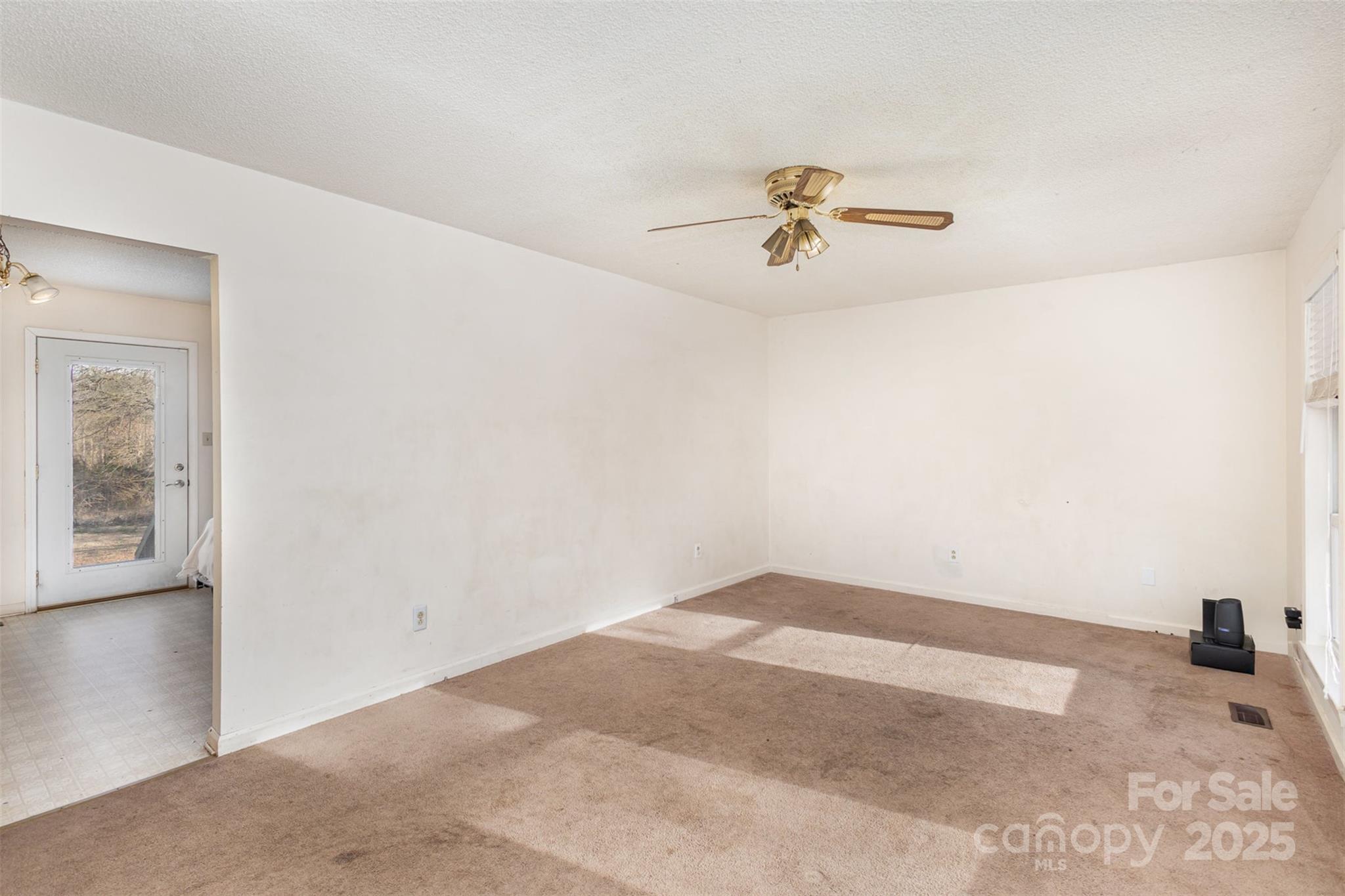 2888 Robinson Road Newton, NC 28658 - Photo 5 of 26 an empty room with a chandelier fan and windows