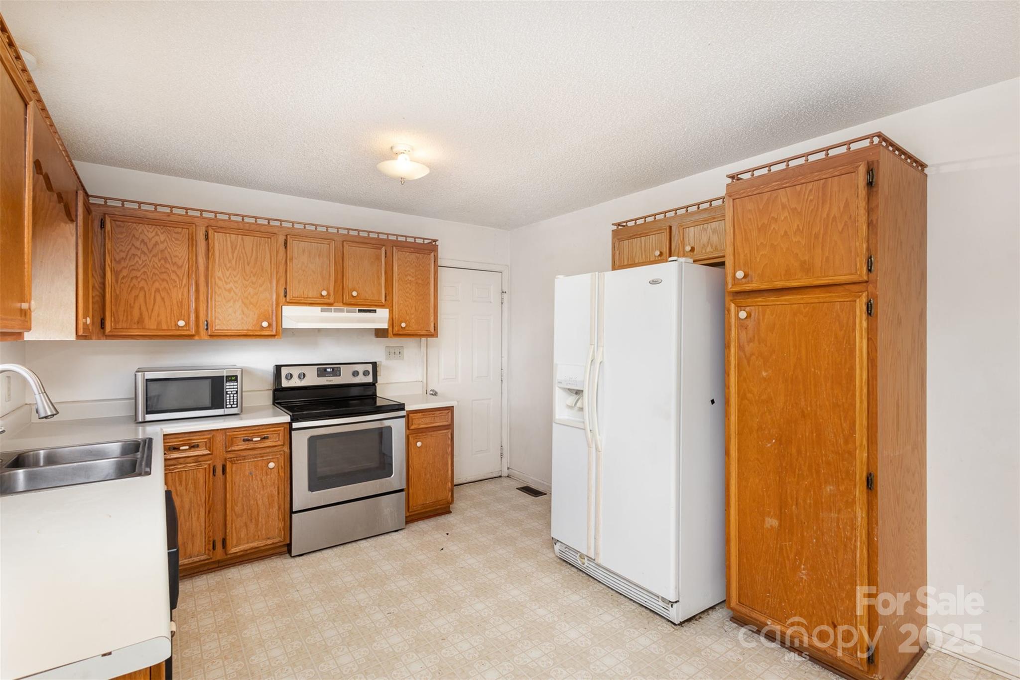 2888 Robinson Road Newton, NC 28658 - Photo 10 of 26 a kitchen with a refrigerator a stove top oven and cabinets