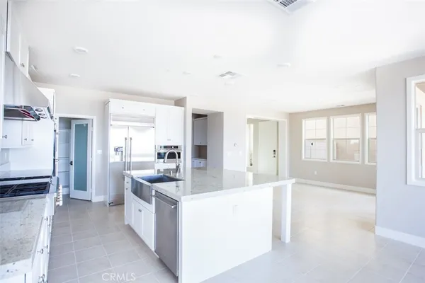 a large kitchen with kitchen island a sink stainless steel appliances and cabinets