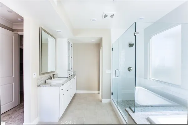 a spacious bathroom with a double vanity sink a mirror and a shower
