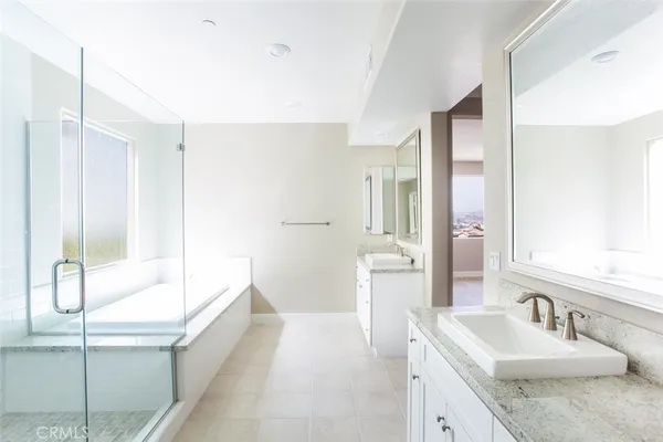 a bathroom with a tub sink and mirror